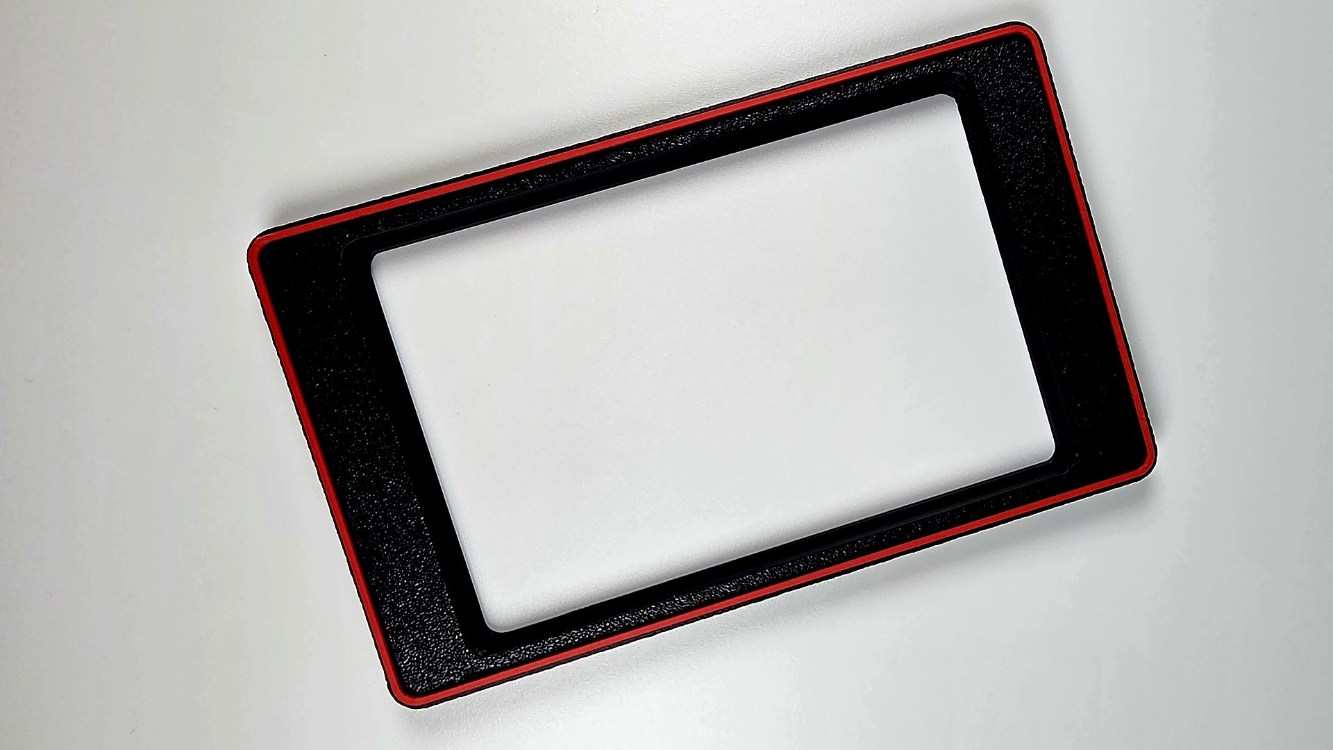 A 3D printed mag insert and bumper in black with a scarlet red ring, photographed flat on a white surface
